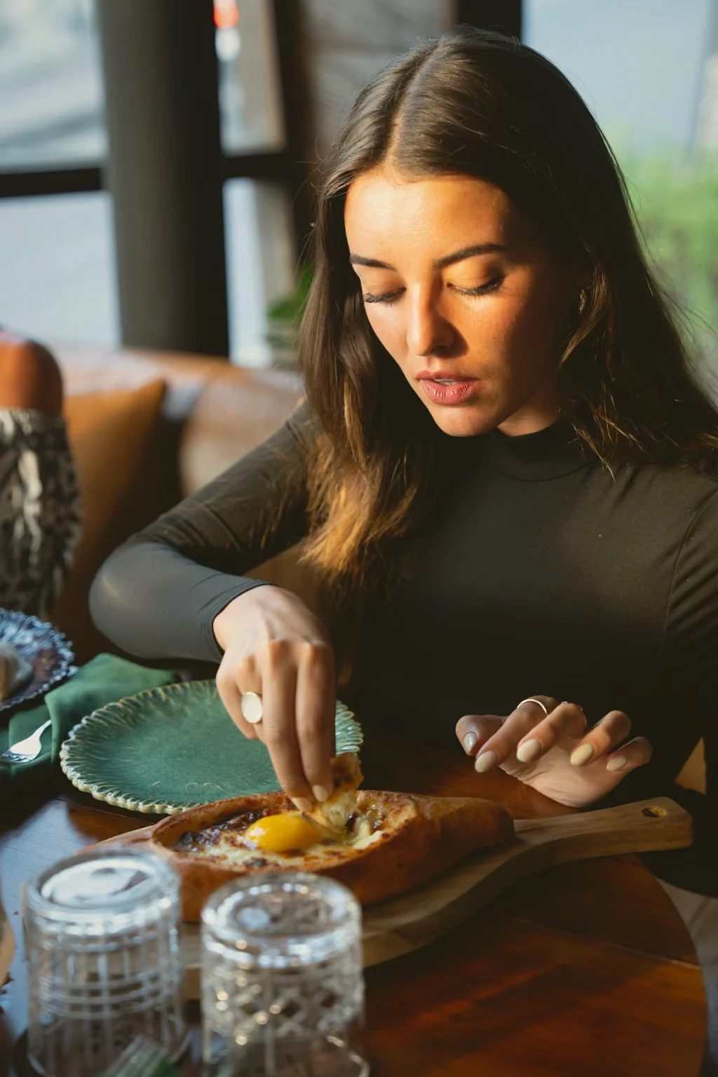 Guest enjoying Adjarian khachapuri at Tarragon, a Georgian restaurant in Uluwatu