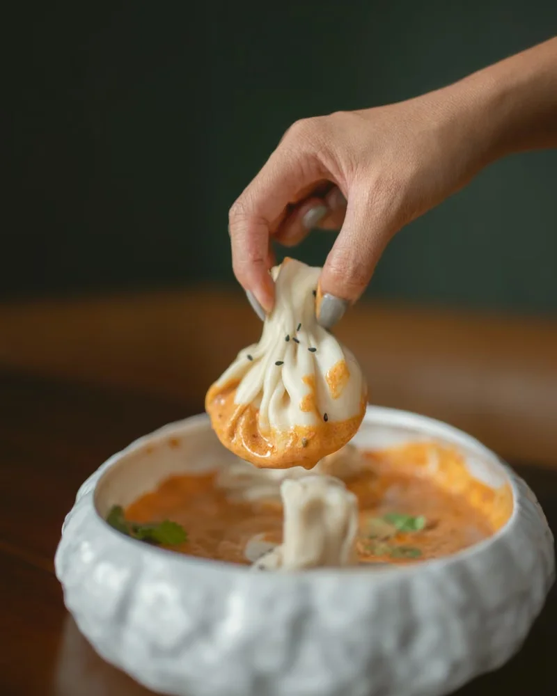 Hand-folded khinkali dipped in sauce at Tarragon Georgian restaurant, Bali
