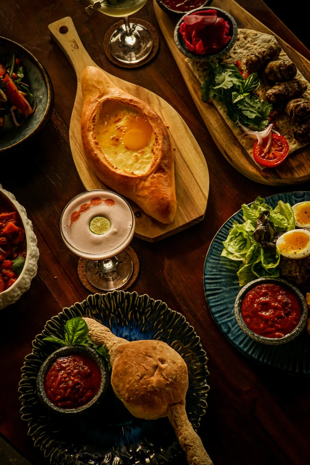 Khachapuri adjariano, kebab y ensaladas en una mesa georgiana en Tarragon, Uluwatu