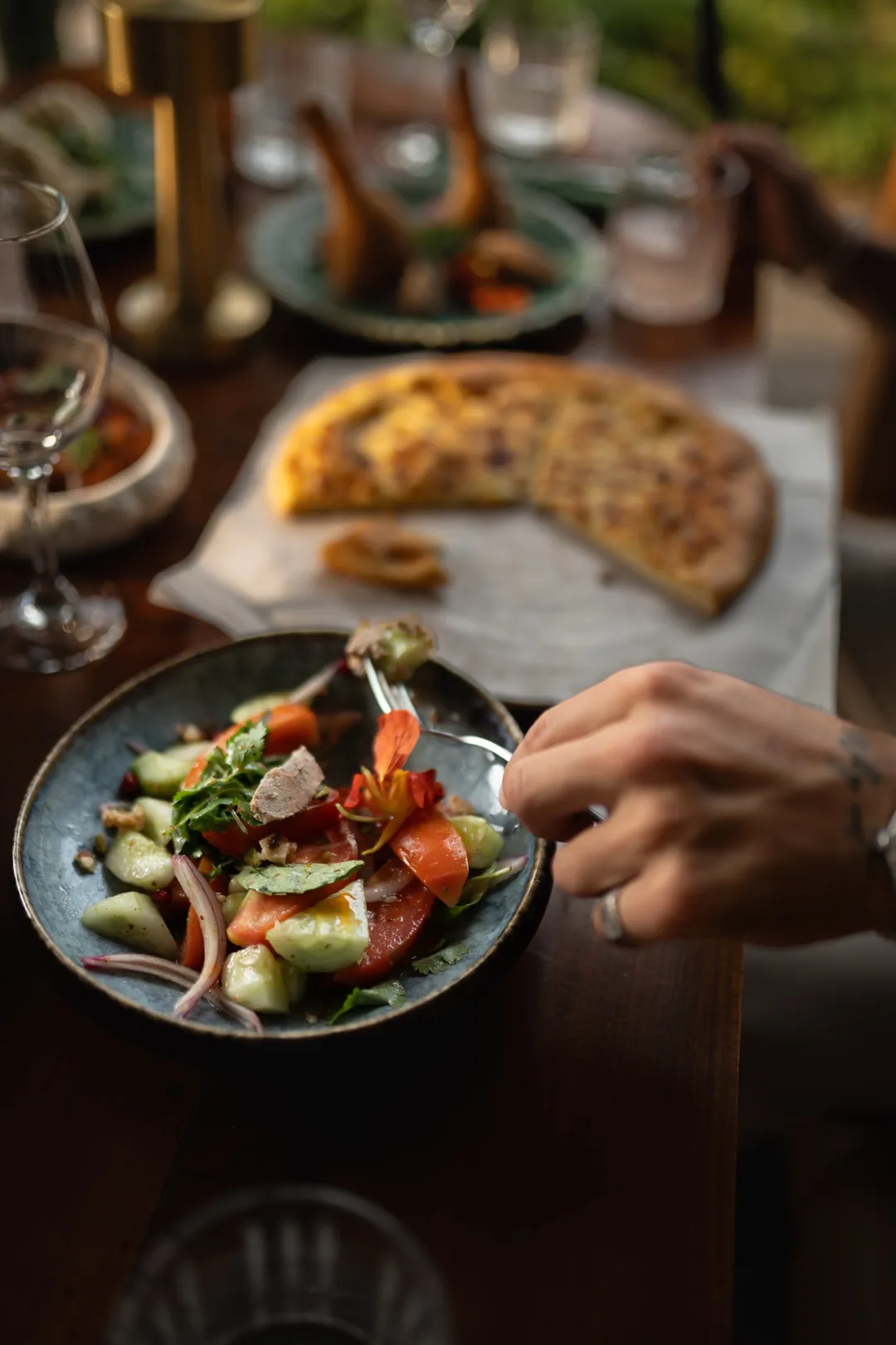 Ensalada georgiana y pan de queso en una mesa compartida en Tarragon, Uluwatu