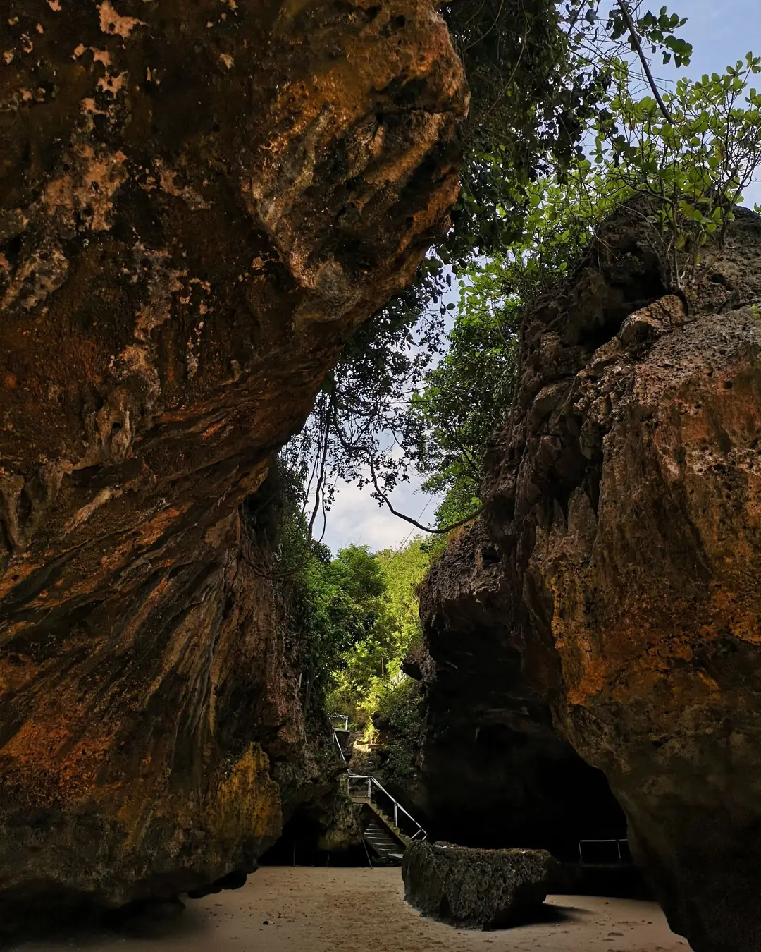 Rock staircase leading down to Padang Padang beach between limestone cliffs, Uluwatu, Bali